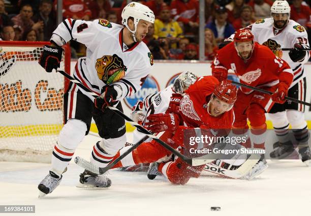 Niklas Hjalmarsson of the Chicago Blackhawks tries to get the puck past the diving Justin Abdelkader of the Detroit Red Wings during the second...