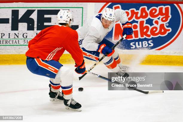 Karson Kuhlman skates against Travis Mitchell of the New York Islanders at Northwell Health Ice Center at Eisenhower Park during training camp on...