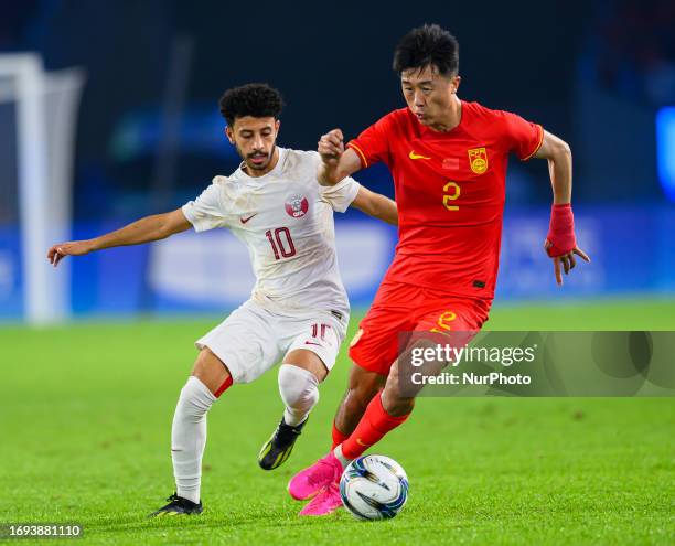 Yang of China and BINSABAA Khaled of Qatar battle for the ball during the 19th Asian Games Hangzhou match between China and Qatar Huanglong Sports...