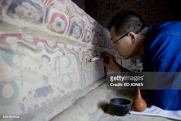 To go with AFP story China-heritage-technology-art,FEATURE by Sebastien Blanc In a photo taken on May 13, 2013 a technician restores one of the Mogao...
