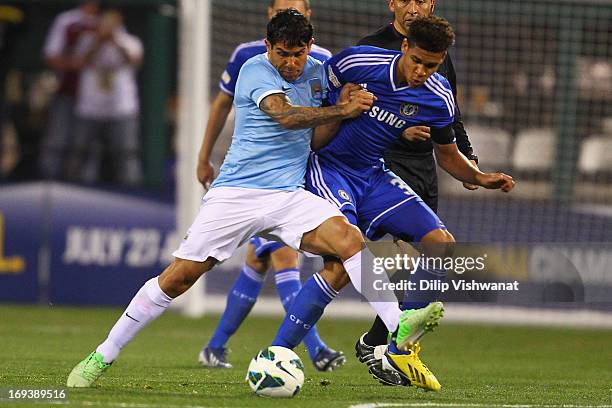 Carlos Tevez of Manchester City fights Ruben Loftus-Cheek of Chelsea for the ball during a friendly match at Busch Stadium on May 23, 2013 in St....