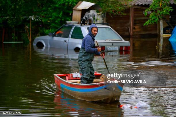 Man rides a boat on a flooded street in Porto Alegre, Brazil on September 27, 2023. The state of Rio Grande do Sul suffered a cyclone that destroyed...