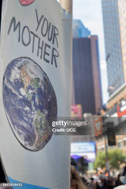 Handmade sign, captioned Your Mother, shows image of Earth from space, March to End Fossil Fuels, New York, New York.