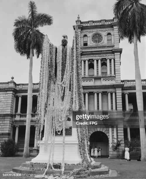 The statue of Hawaiian Royal Kamehameha I draped with a lei during the Kamehameha Day celebrations, with the Ali'iolani Hale, the home of the Hawaii...