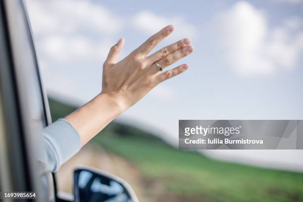 unrecognizable woman, embarking adventure, stucking hand out of car window, greeting magnificent autumn day and enjoying travelling in non-urban area. - non motorised vehicle stock pictures, royalty-free photos & images