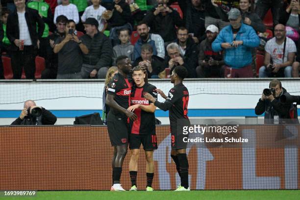 Florian Wirtz of Bayer Leverkusen celebrates with teammates Victor Boniface and Nathan Tella after scoring the team's first goal during the UEFA...