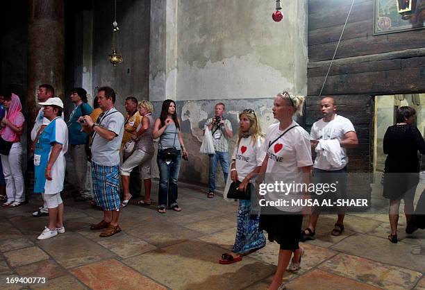 Tourists wearing T-shirts reading "I love Palestine" visit the Church of the Nativity on May 24, 2013 in the West bank town of Bethlehem after being...