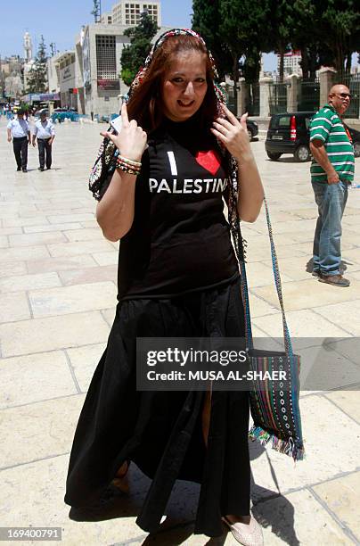 Tourist walks wearing a T-shirt reading "I love Palestine" that she received from Palestinian youths as part of a campaign to raise awareness among...