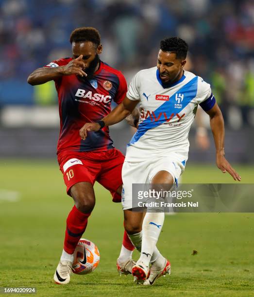 Salem Al Dawsari of Al Hilal Club battles for the ball with Nkoudou of Damak during the Saudi Pro League match between Damak and and Al Hilal at...
