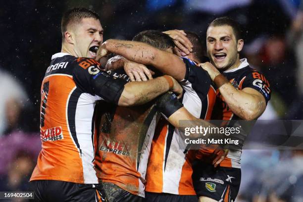 Jack Buchanan of the Tigers celebrates with Curtis Sironen and Robbie Farah during the round 11 NRL match between the Wests Tigers and the North...