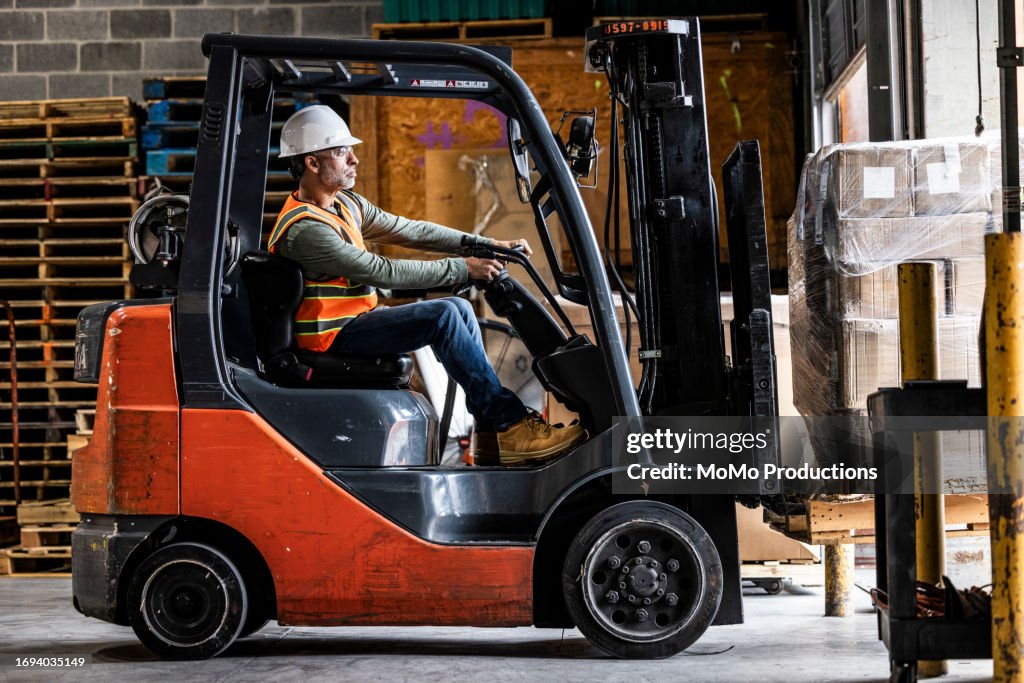 Warehouse employee driving forklift