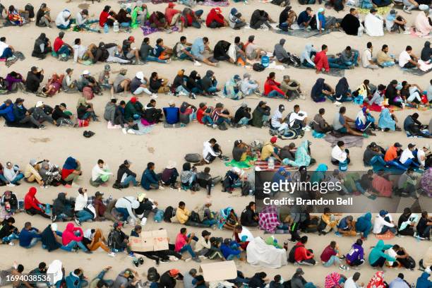 In an aerial view, migrants are seen grouped together while waiting to be processed on the Ciudad Juarez side of the border on September 21, 2023 in...