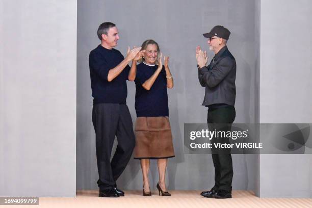 Fashion designers Miuccia Prada, Raf Simons and Fabio Zambernardi walk the runway during the Prada Ready to Wear Spring/Summer 2024 fashion show as...