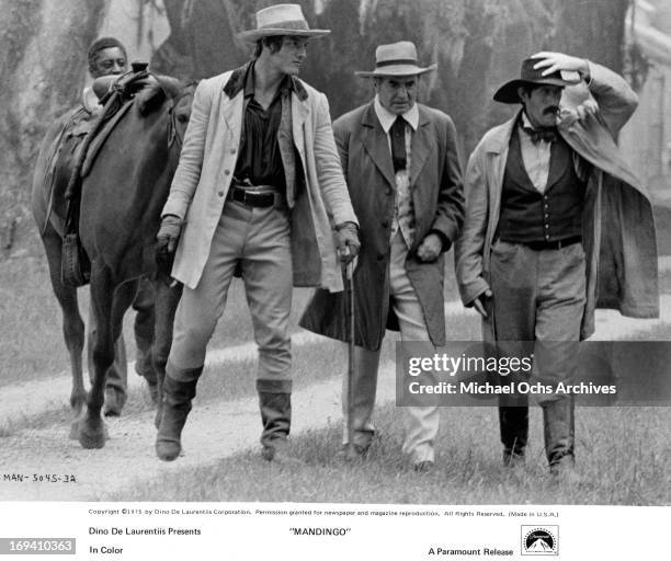 Perry King, James Mason, and Paul Benedict tour slave headquarters in a scene from the film 'Mandingo', 1975.