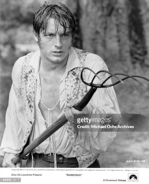 Perry King holding pitchfork in a scene from the film 'Mandingo', 1975.