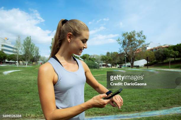 giovane donna esercitando nel parco - tecnología foto e immagini stock