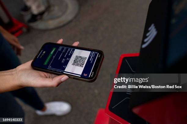 Fan presents a digital ticket before a game between the Boston Red Sox and the Tampa Bay Rays on September 27, 2023 at Fenway Park in Boston,...