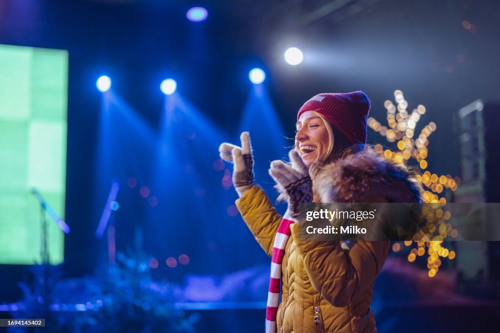 Young woman on a Christmas music concert outdoors