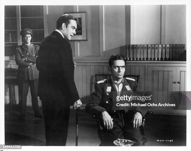 Richard Johnson questions a general in a scene from the film 'Operation Crossbow', 1965.