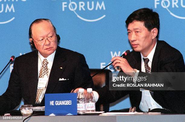 Minoru Murofushi , chairman of Japan's Itochu Corporation looks at He Guangbei , the Bank of China's executive assistant president as he speaks...