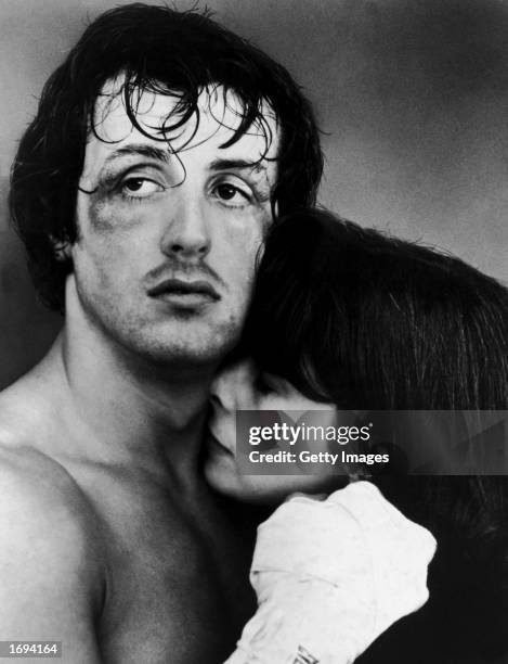 American actors Sylvester Stallone and Talia Shire embrace in a headshot still from the film, 'Rocky,' directed by John G. Avildsen, 1976. Stallone's...