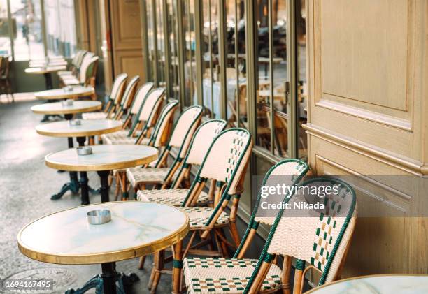 tables and chairs in sidewalk cafe, paris, france - restaurant paris stock pictures, royalty-free photos & images