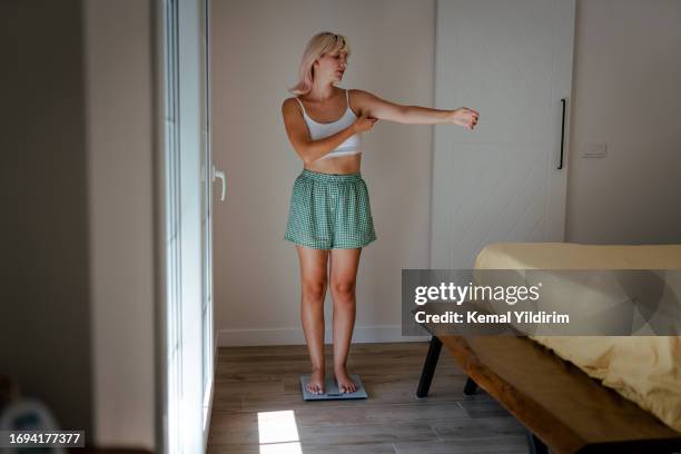 young healthy girl on home scales - happiness meter stock pictures, royalty-free photos & images