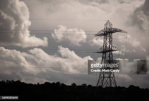 Electrical pylons carry electricity cables across fields on September 17, 2023 near Bristol, England. The National Grid is seen as critical...