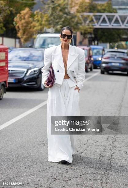 Gili Biegun wears white cropped blazer, wide leg pants, burgundy bag outside Genny during the Milan Fashion Week - Womenswear Spring/Summer 2024 on...