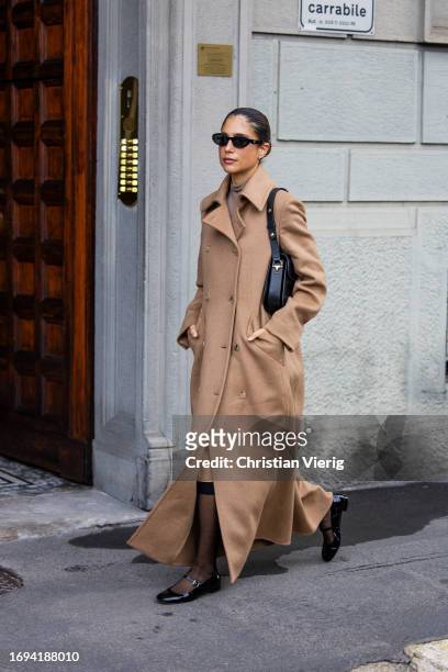 Belen Hostalet wears beige double breasted coat, black Celine bag, knee high socks, sunglasses, black shoes outside Max Mara during the Milan Fashion...