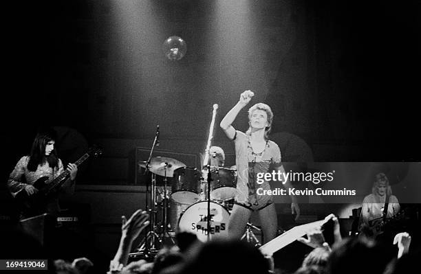 English singer David Bowie performs on stage with bass player Trevor Bolder , drummer Mick 'Woody' Woodmansey , and guitarist Mick Ronson at Free...