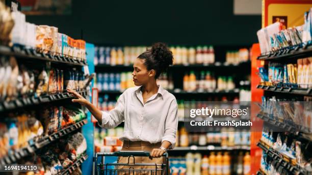 une belle femme cubaine heureuse faisant ses courses au supermarché - comparison stock photos et images de collection