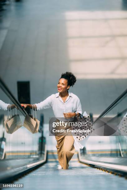 a happy beautiful cuban woman looking away while going shopping - shopping centre stock pictures, royalty-free photos & images