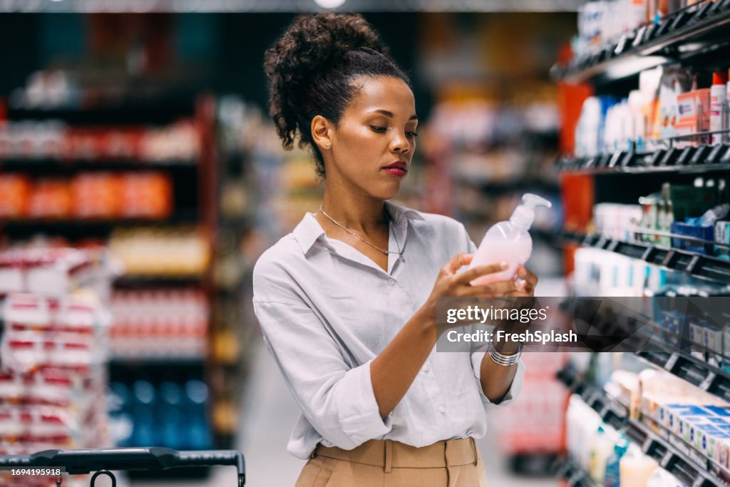 Eine ernsthafte schöne kubanische Frau, die im Supermarkt einkauft