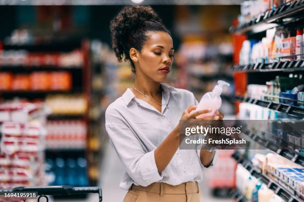 una hermosa mujer cubana seria comprando en el supermercado - mercancía fotografías e imágenes de stock