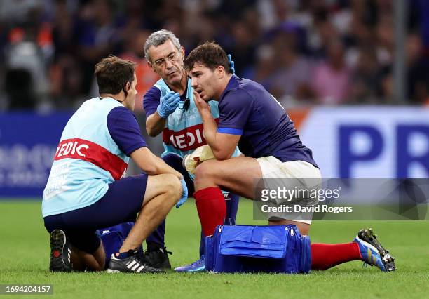 Antoine Dupont of France receives medical treatment following head contact with Johan Deysel of Namibia during the Rugby World Cup France 2023 match...