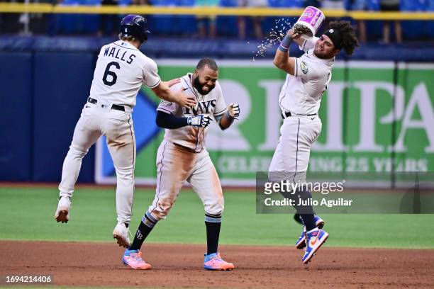 Manuel Margot of the Tampa Bay Rays celebrates with Taylor Walls and Jonathan Aranda after hitting a walk-off RBI single to defeat the Los Angeles...