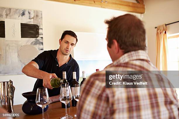 sommelier pouring wine at tasting - sommelier stockfoto's en -beelden