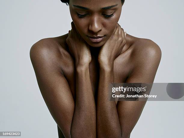 black female looking down covering chest with arms - beautiful skin stock pictures, royalty-free photos & images