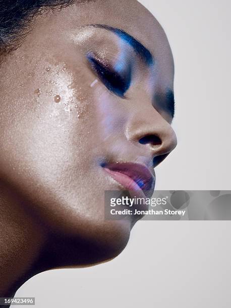 close up of black females face with water on cheak - eyeshadow foto e immagini stock