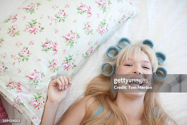 woman laying with curlers in hair - hair rollers stock pictures, royalty-free photos & images