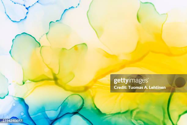 macro close-up of soft yellow, blue and green alcohol ink layers and abstract shapes on white. - blue gradient background stock pictures, royalty-free photos & images