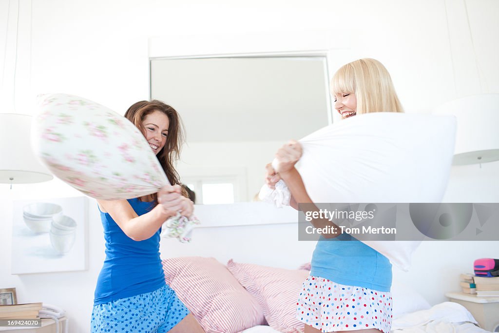 Femmes oreiller se battre dans la chambre
