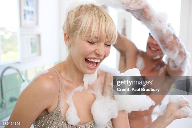 couple covered with soap suds in bathroom - soap suds stock pictures, royalty-free photos & images