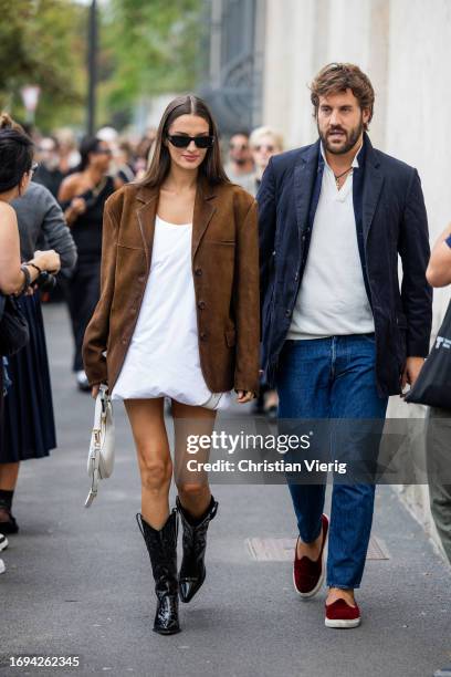 Gabrielle Caunesil Pozzoli wears brown wild leather jacket, white dress, bag, black cowboy boots outside Prada during the Milan Fashion Week -...