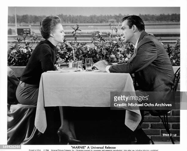 Tippi Hedren and Sean Connery at race track table in a scene from the film 'Marnie', 1964.
