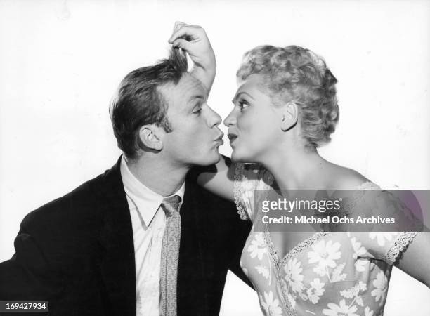 Judy Holliday plays with Aldo Ray's hair in publicity portrait for the film 'The Marrying Kind', 1952.