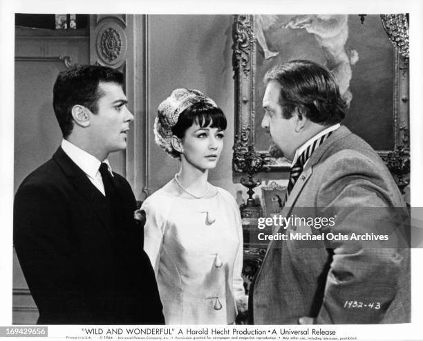 Tony Curtis and Christine Kaufmann listen as Jacques Aubuchon promises to forgive their runaway marriage in a scene from the film 'Wild And...