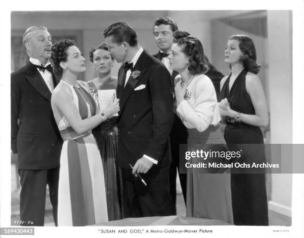 Joan Crawford and Bruce Cabot have the attention of Nigel Bruce, Rose Hobart, John Carroll, Ruth Hussey, and Rita Hayworth in a scene from the film...