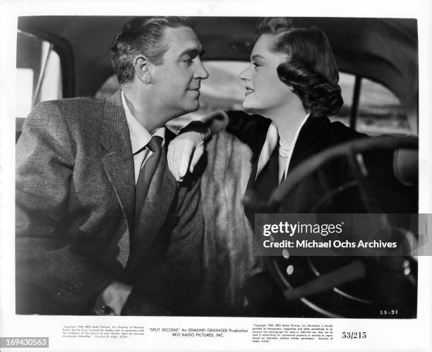 Stephen McNally looking fondly at Alexis Smith in the car in a scene from the film 'Split Second', 1953.